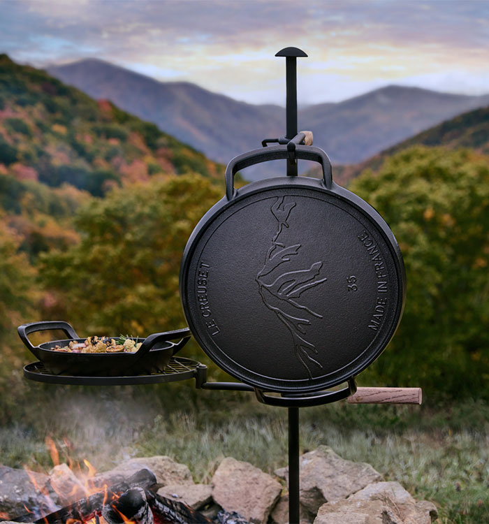 alpine pizza pan hangs on post by an open fire