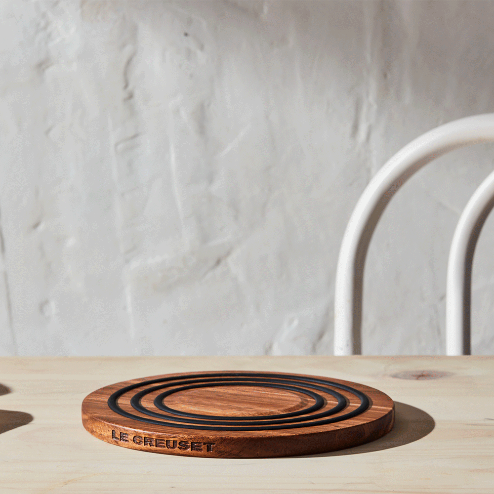 The wooden spoon rests in a Dutch oven filled with soup