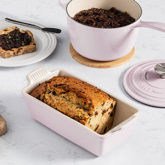 quickbread in a loaf pan next to cast iron saucepan