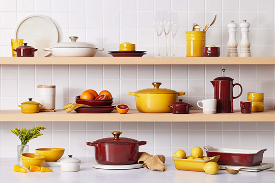 elegant shelves filled with decor and cookware in wine red and verdant green