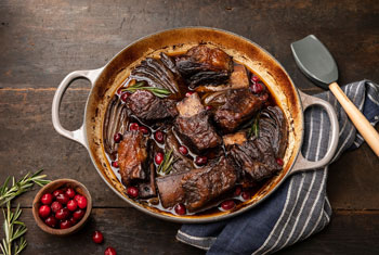 braised meat and veggies in a cast iron braiser