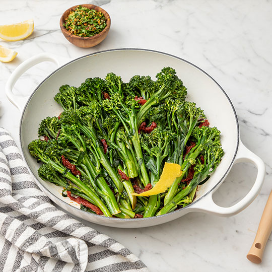 bright green broccolini in a white braiser