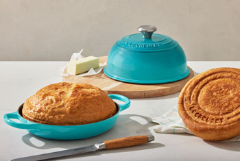 Le Creuset bread oven in caribbean blue with loaves of bread