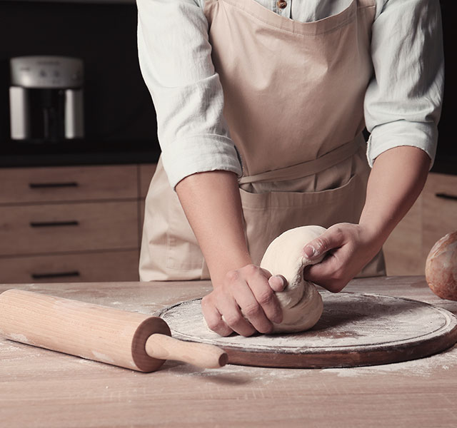 kneading bread dough on a floured surface