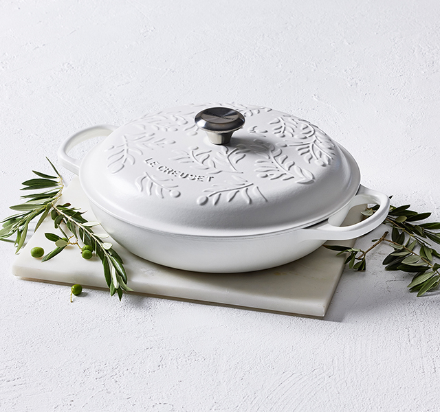 olive green cast iron braiser with olive branch design embossed on the lid