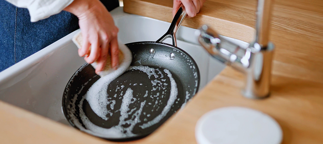 hands placing a cast iron braiser on a counter