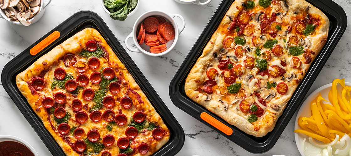 two rectangular pizzas baked on nonstick sheet pans