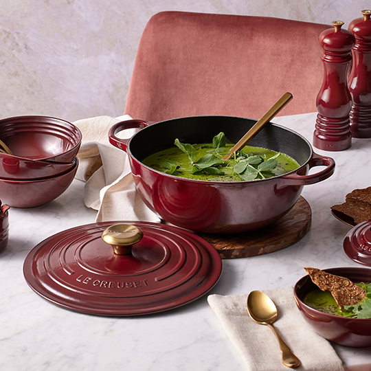 dolive green dutch oven with rounded bottom filled with stew