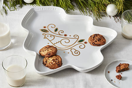 white platter shaped like a Christmas tree with a partridge design enamelled on the surface including shimmering gold leaf