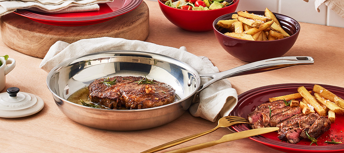 browned pork chops in a stainless skillet