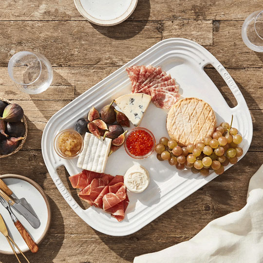 serving tray filled with meat, cheese, fruit and dips