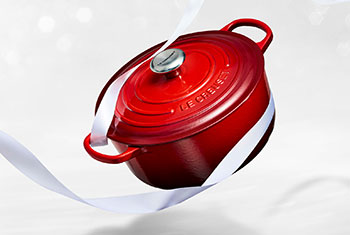 red dutch oven with white ribbon