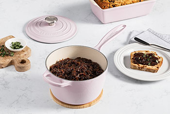 dark brown jam in a soft pink saucepan