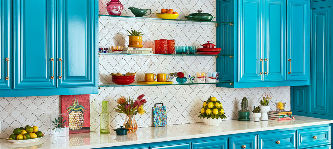 bold blue cabinets and lots of art create big impact in an over-the-top kitchen