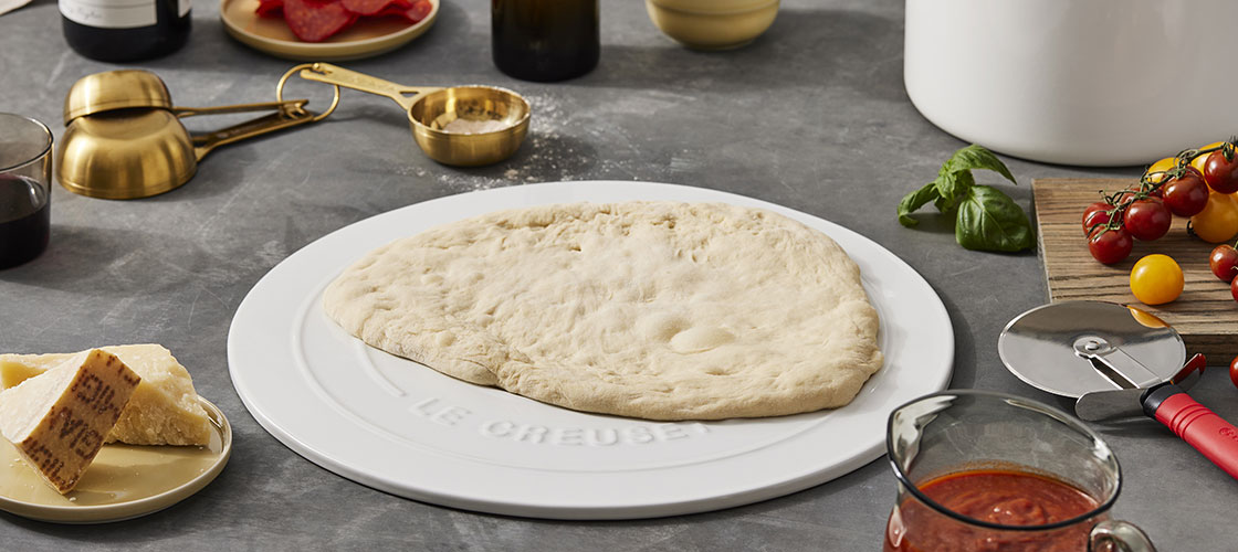 pizza dough on a stoneware pizza stone