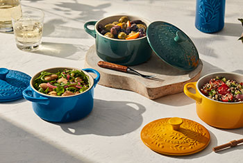 trio of multicolored mini cocottes with embossed olive branch designs on lids