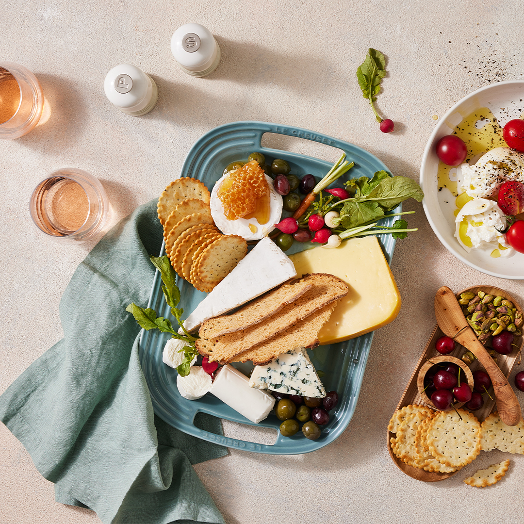 oysters in shells on a bed of salt atop a black Le Creuset serving platter