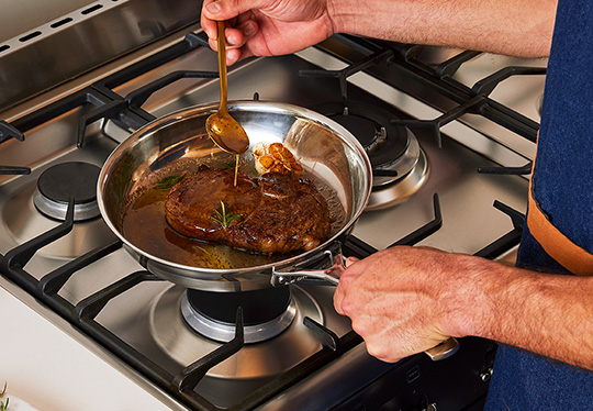 pork chops in a stainless steel fry pan