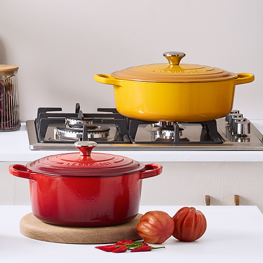 a woman places a dutch oven filled with soup on the table