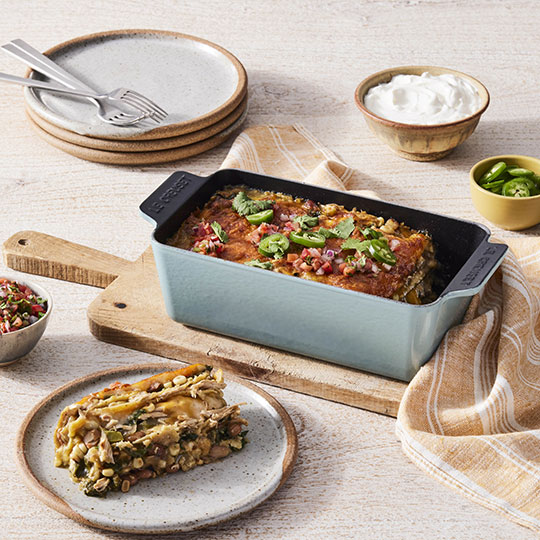 layered casserole dish in a loaf pan topped with deep red sauce