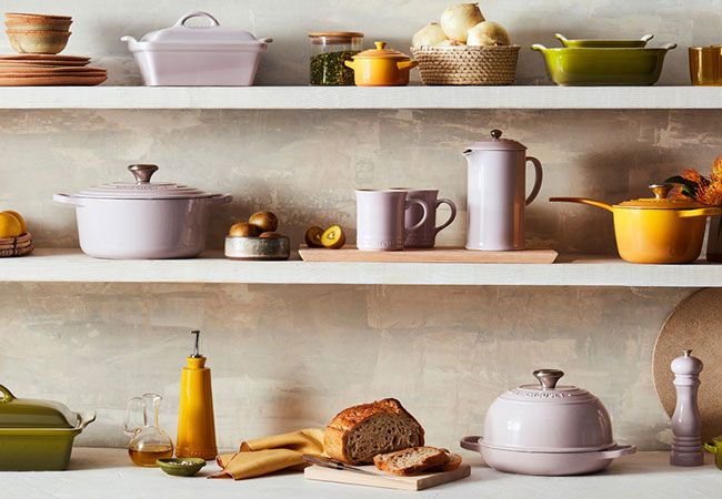 soft pink cookware mixed with greens and yellows on a shelf