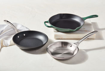 a variety of fry pans on a counter