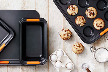 assorted nonstick bakeware items pictured with muffins