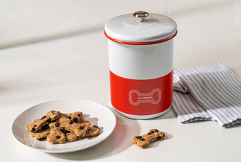 a plate of bone shaped baked treats next to a pet collection canister