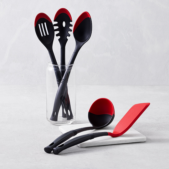 red and black bi-material spatula next to a sheet pan of cookies