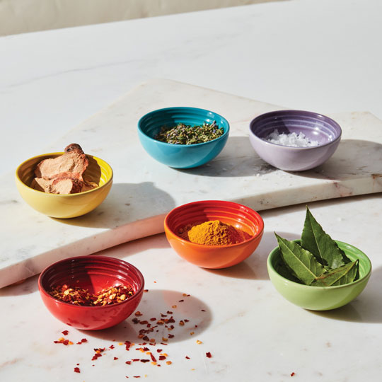 herbs and spices in small colorful stoneware pinch bowls