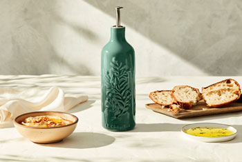 green olive oil cruet with olive branch design embossed on the front